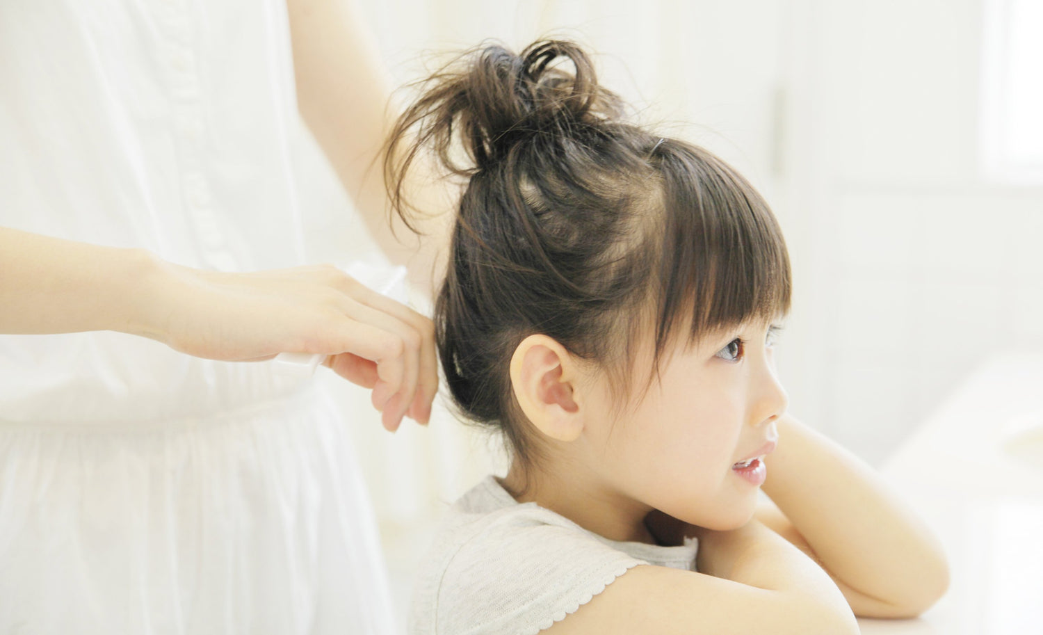 母親が風呂上がりの笑顔の子供の頭髪を梳かす